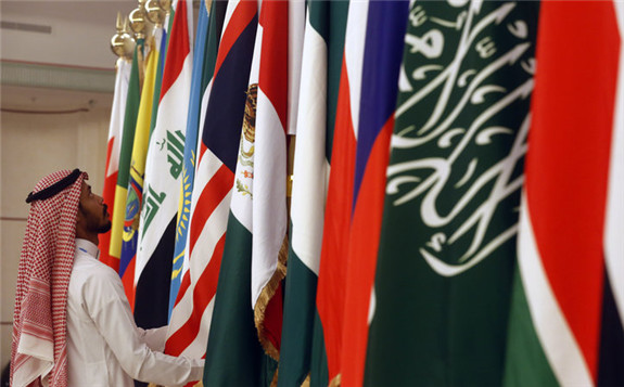 A Saudi worker adjusts flags of participating countries before a meeting of energy ministers from OPEC and its allies in Jeddah, Saudi Arabia, on May 19. OPEC+ countries met again in Vienna on Monday and Tuesday and agreed to formalize their relationship in a 