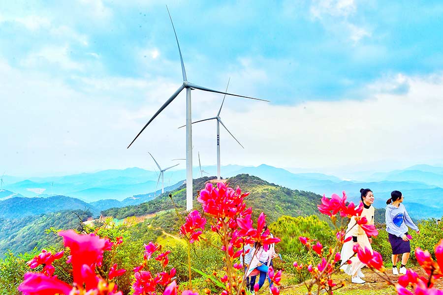 Travelers visit a wind farm in Ganzhou, Jiangxi province, in April. [Photo by Zhu Haipeng/for China Daily]