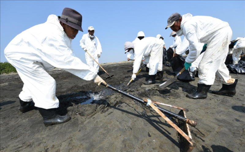 Locals clean the beach affected by the oil spill at a shoreline in Karawang, West Java province, Indonesia, August 1, 2019 in this photo taken by Antara Foto. Antara Foto via REUTERS