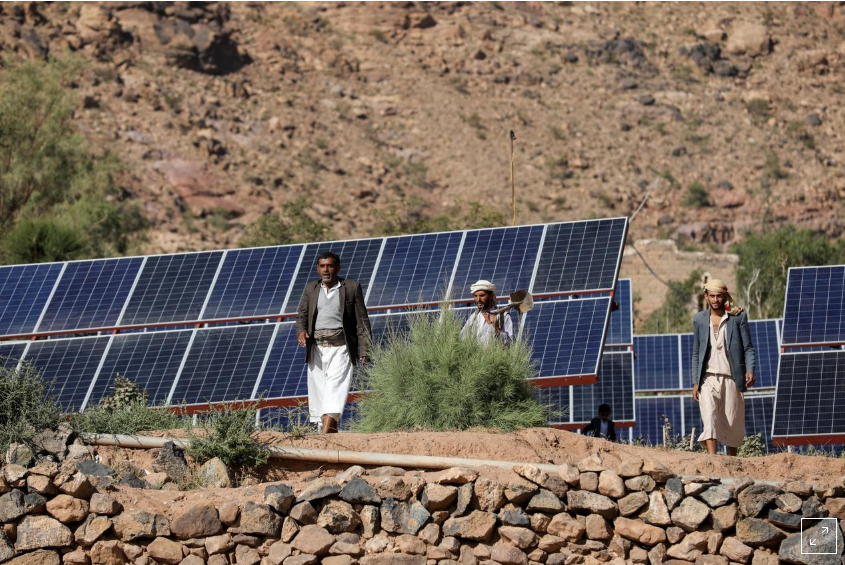 Farmers walk next to solar panels at a farmland in Wadi Dhahr near Sanaa, Yemen October 28, 2019.