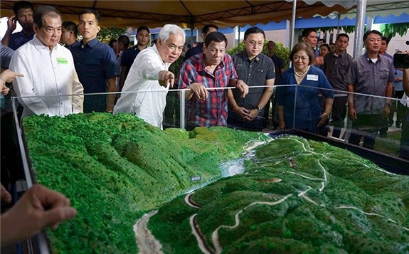 INVESTING IN RENEWABLE ENERGY. Alsons Consolidated Resources, Inc. (ACR) Director Nicasio Alcantara showa to President Rodrigo Duterte the scale model of the Siguil Hydro Power Corporation's 14.5-Megawatt Hydropower Project during its launch in Maasim, Sarangani Province on November 22, 2019. Also in photo are ACR chairman Tomas I. Alcantara, Senator Christopher Lawrence Go, and Energy Regulatory Commission chairperson Agnes VST Devanadera. (Joey Dalumpines, Presidential photo)
