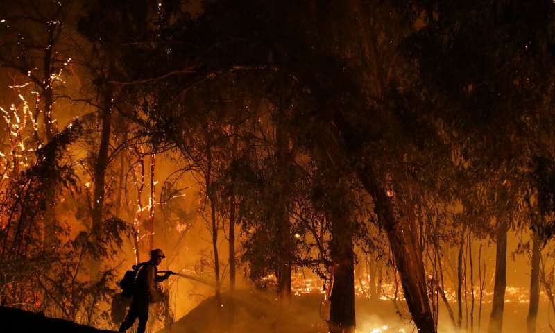 In this Oct. 31, 2019, file photo, a firefighter battles a wildfire known as the Maria Fire in Somis, Calif. A new technology being tested by California utilities, such as Pacific Gas & Electric Co. and Southern California Edison, is aimed at diagnosing problems before they could cause power outages or spark wildfires. (AP Photo/Marcio Jose Sanchez, Fire)