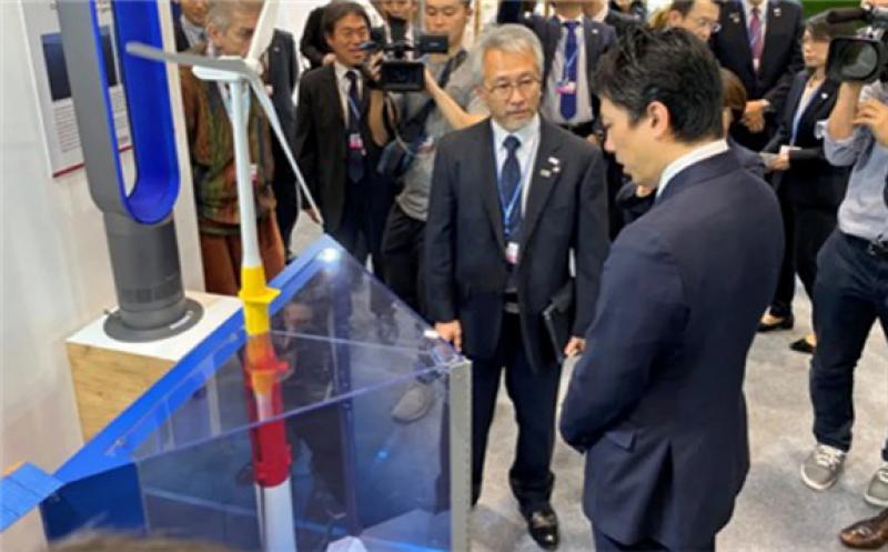Environment Minister Shinjiro Koizumi, right, is briefed on Japanese-made offshore wind generators at the COP25 climate gathering in Madrid.