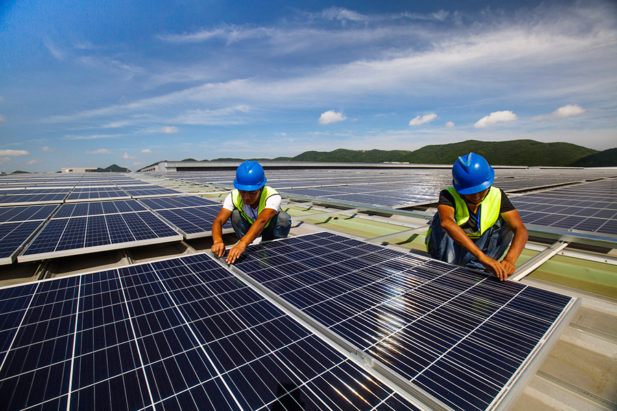 Workers install solar power generation panels in Dinghai district of Zhoushan, Zhejiang province, on July 9, 2019.