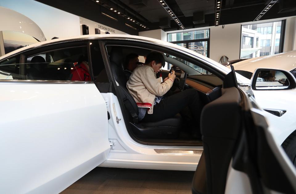 SHANGHAI, CHINA - NOVEMBER 22: A man experiences China-built Tesla Model 3 with its brand name in Chinese characters at a Tesla store on November 22, 2019 in Shanghai, China. China's homegrown Tesla Model 3 will be sold at a starting price of 355,800 yuan (about 50,560 US dollars). (Photo by Zhang Hengwei/China News Service/VCG via Getty Images)VCG VIA GETTY IMAGES