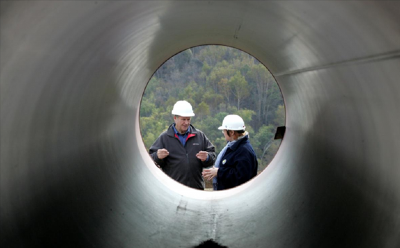 FILE PHOTO: Engineers talk as they stand next to pipes to be used for a pipeline that is part of the Sakhalin-2 project, some 220 km (137 miles) north of Yuzhno-Sakhalinsk on Sakhalin Island October 12, 2006. REUTERS/Sergei Karpukhin (RUSSIA)/File Photo
