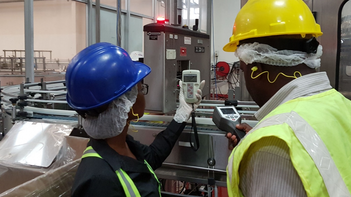 Two HSRA Staff members take readings from the X-ray level gauge at the Pepsi-Cola Bottling Company Limited in Kingston, Jamaica. (Photo: HSRA)