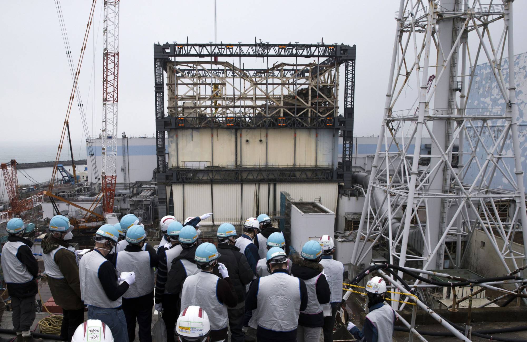 Members of the media look out at the No. 1 reactor building of the Fukushima No. 1 nuclear power plant in February 2017. | BLOOMBERG