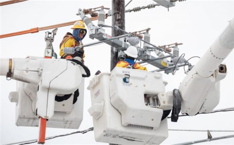 Workers repair a power line in Austin, Texas, U.S., on Wednesday, Feb. 18, 2021.