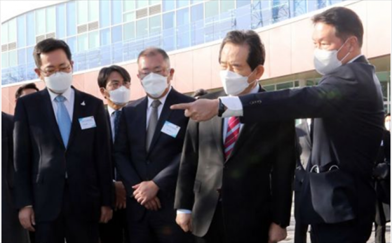 SK Group chairman Chey Tae-won (right) explains his group’s plan to build a liquefied hydrogen plant to Prime Minister Chung Sye-kyun (second from right).