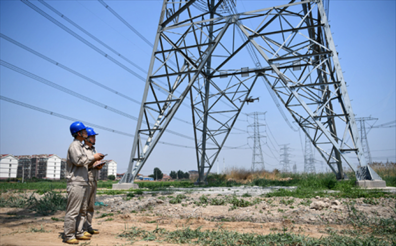 State Grid employees inspect high-voltage power lines in Tianjin. [Photo/Xinhua]