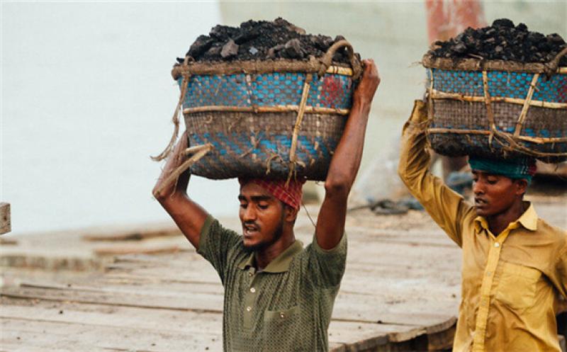 Two men carry coal in Chittagong, a port city on the south-eastern coast of Bangladesh. (Photo: Flickr/Adam Cohn)