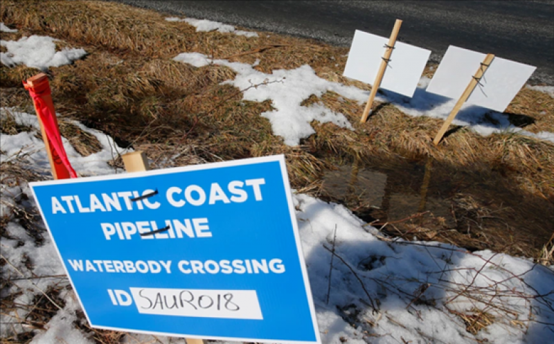FILE – This Feb. 8, 2018, file photo shows signs that mark the route of the Atlantic Coast Pipeline in Deerfield, Va. The developers of the now-canceled Atlantic Coast Pipeline have laid out plans for how they want to go about unwinding the work that was done for the multistate natural gas project and restoring disturbed land. In a filing with federal regulators made public Tuesday, Jan. 5, 2021, the pipeline company proposed an approximately 24-month timeline for efforts across West Virginia, Virginia and North Carolina. (AP Photo/Steve Helber, File)