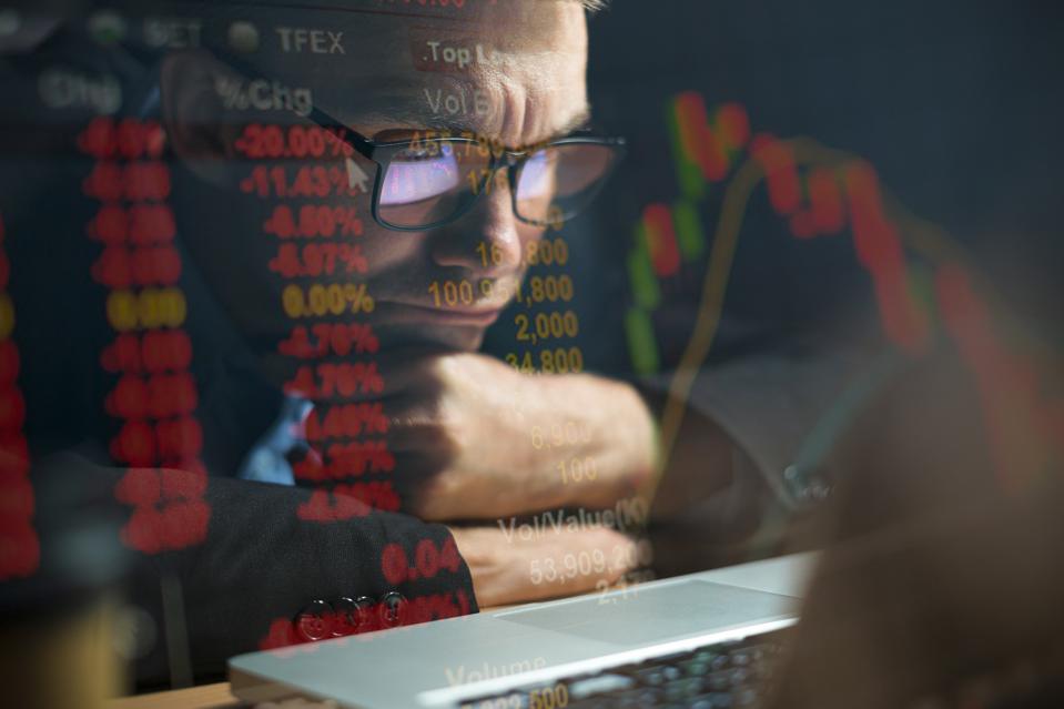 Businessman checking stock market data on computer screen and contemplating GETTY