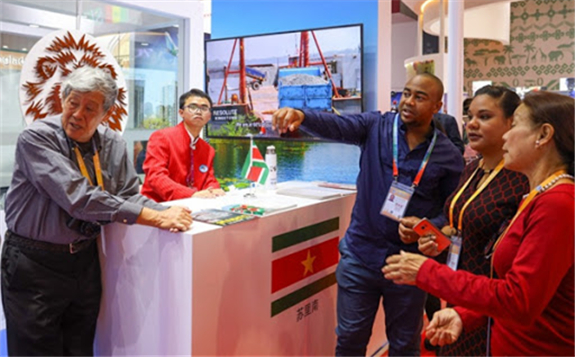 A staff member (3rd R) introduces Suriname to visitors at the first China International Import Expo (CIIE) in Shanghai, east China, Nov. 6, 2018. [Photo/Xinhua]