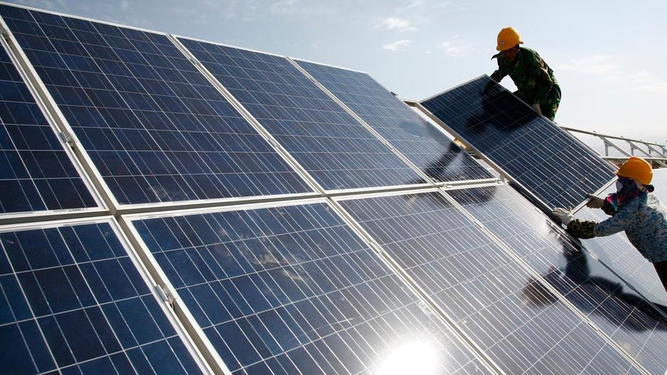 Workers install solar panels at a photovoltaic power station in Hami in northwestern China. The world's second-biggest economy installed 136 gigawatts of renewables capacity last year, 49 gigawatts of which was solar. AP Photo