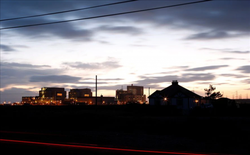 Car lights stream past a home near Dungeness nuclear power station in Kent, southern England, December 4, 2012.