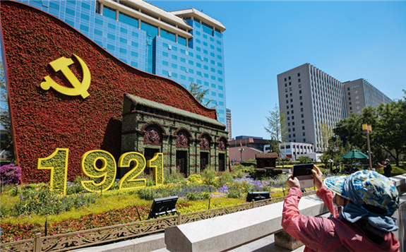 A visitor takes a photo of a floral decoration that has been put up along the Chang'an Avenue in Beijing to celebrate the 100th anniversary of the founding of the Communist Party of China (CPC) on Monday. Under the theme of 
