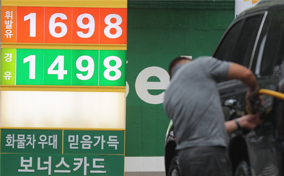 A driver refills his car at a gas station in Seoul on Sunday, as the nation's average gasoline prices surpassed 1,600 won ($1.40) per liter for the first time since November 2018. (Yonhap)