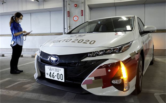 A staff member uses a smartphone app for drivers to unlock Toyota Motor Corp. Mirai fuel cell electric vehicle (FCEV) during a demonstration of the transport operation support system for the Tokyo 2020 Games on July 1 in Tokyo. KIYOSHI OTA/GETTY IMAGES