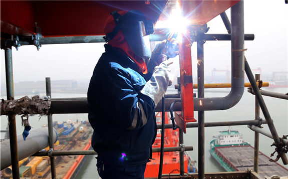 A CNOOC employee works on an offshore oil drilling platform in the Bohai Sea on Feb 20, 2020. [Photo by Jia Lei/For China Daily]