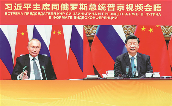 President Xi Jinping talks with Russian President Vladimir Putin during a virtual meeting on Wednesday. China and Russia pledged to bolster cooperation on international affairs and cooperate to effectively protect their security interests. [Photo/Xinhua]