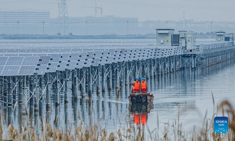Staff members inspect a 550 megawatts photovoltaic (PV) power station in Wenzhou, east China's Zhejiang Province, Dec. 15, 2021. The PV power station in Wenzhou, covering a water area of 4.7 square kilometers, was successfully connected into the grid on Thursday. The project has combined fishery breeding and photovoltaic power generation.(Xinhua)