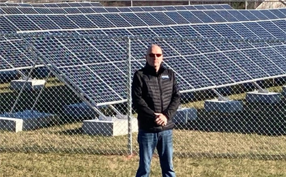 Stewiacke Mayor George Lloy stands next to the town's 240-panel solar field on Saturday, which will soon start feeding power to the provincial grid. (Dale Bogle)